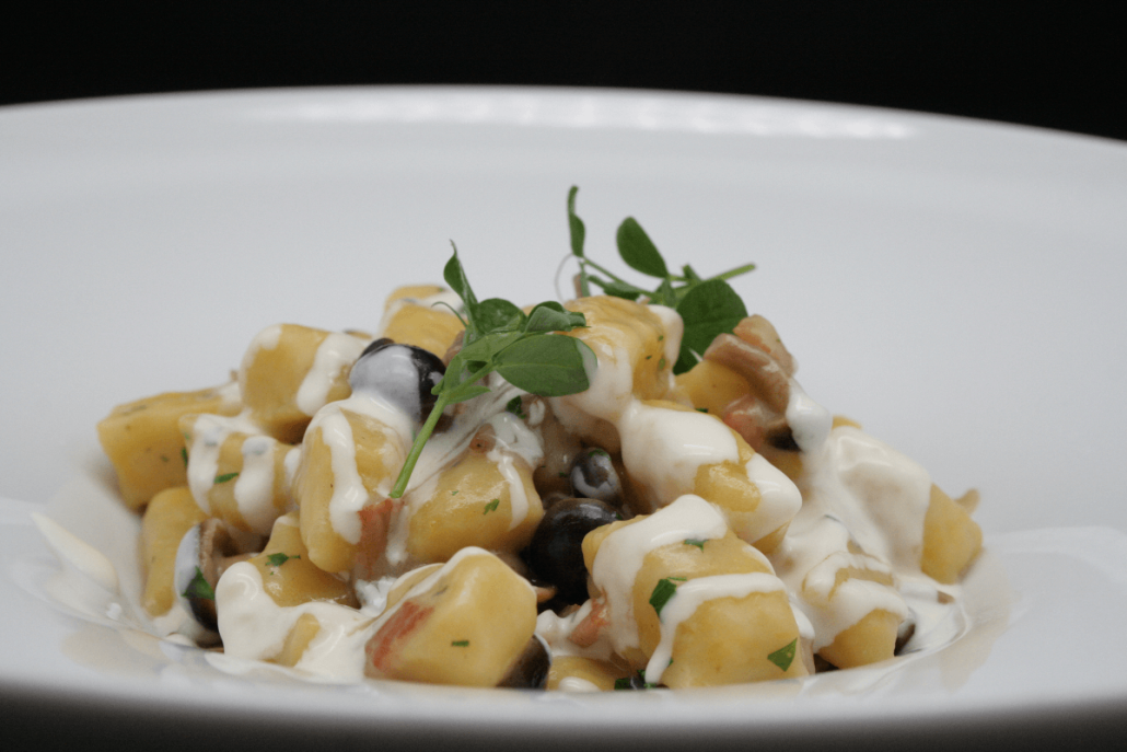 Piatto di gnocchi alla zucca con funghi Pioppini, fonduta di Taleggio e pancetta